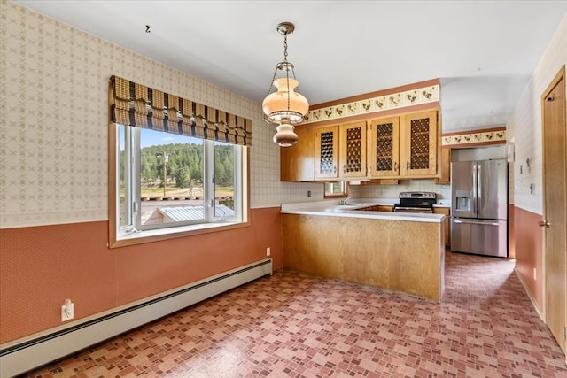 kitchen featuring kitchen peninsula, appliances with stainless steel finishes, sink, tile patterned flooring, and a baseboard heating unit