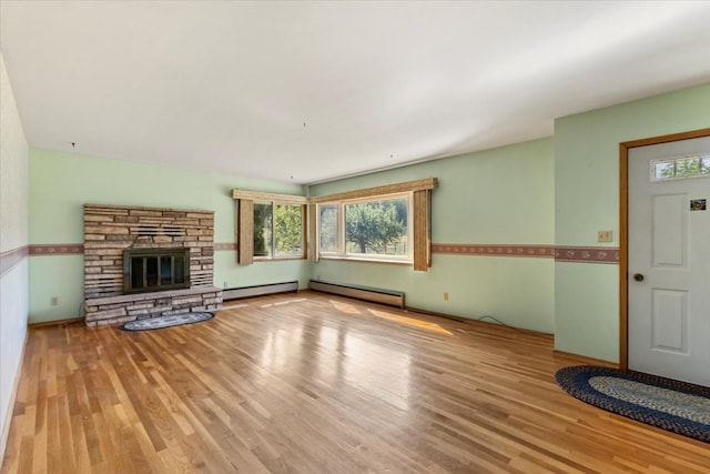 unfurnished living room featuring baseboard heating, light wood-type flooring, and a fireplace