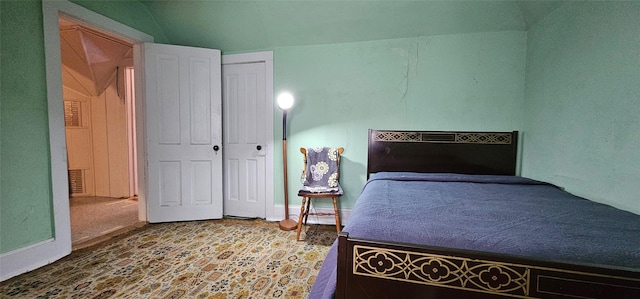 bedroom with vaulted ceiling and a closet