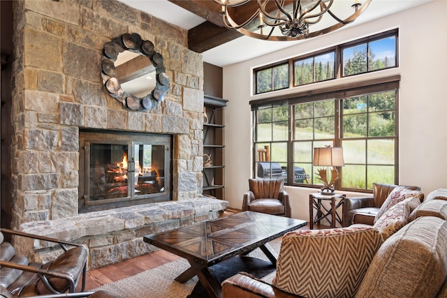 living room with beam ceiling, a notable chandelier, a fireplace, and hardwood / wood-style floors