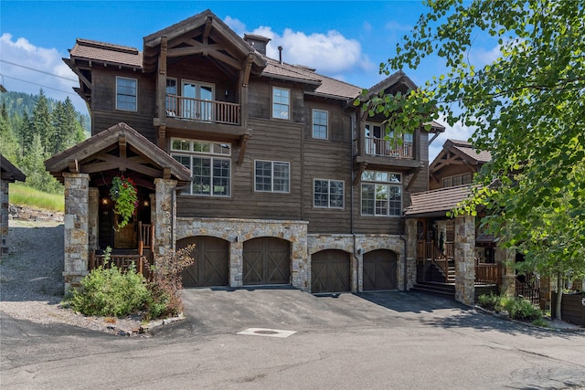 view of front facade featuring a garage and a balcony