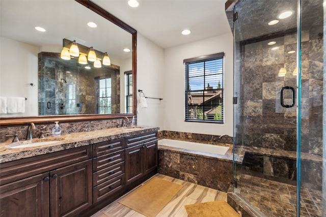 bathroom with double sink vanity, plenty of natural light, and independent shower and bath