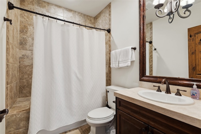 bathroom with toilet, vanity, and an inviting chandelier