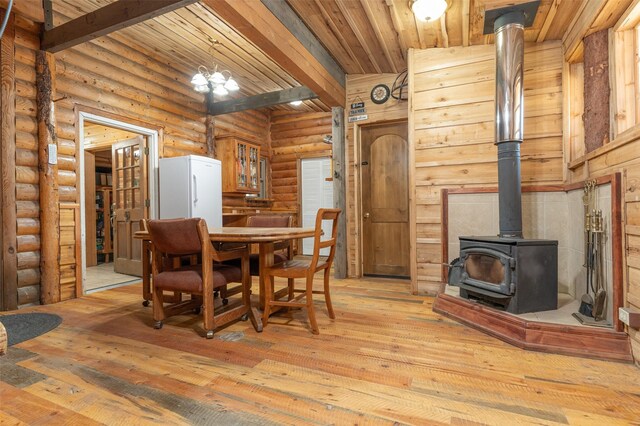 659 US Highway 2 E, Columbia Falls, MT 59912 - dining space with a wood stove, light wood finished floors, and beamed ceiling