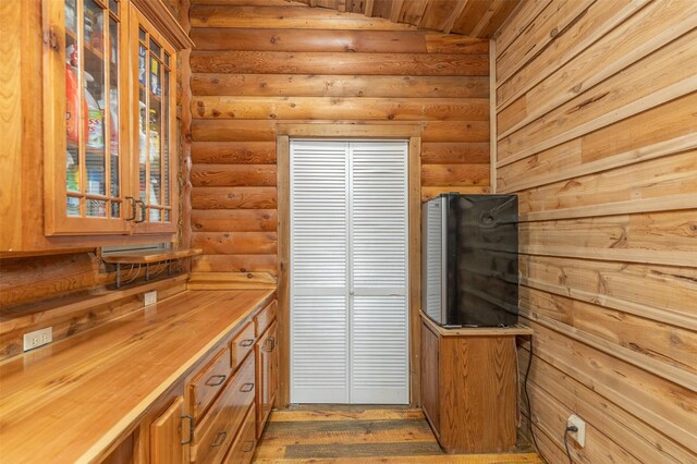 659 US Highway 2 E, Columbia Falls, MT 59912 - kitchen featuring wooden counters, rustic walls, wood finished floors, and glass insert cabinets
