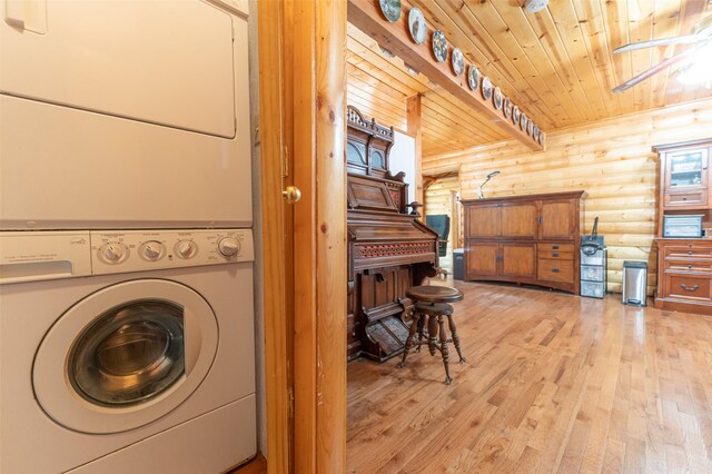 659 US Highway 2 E, Columbia Falls, MT 59912 - laundry room featuring log walls, stacked washer and dryer, wood ceiling, light wood-type flooring, and laundry area