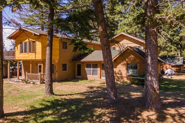 659 US Highway 2 E, Columbia Falls, MT 59912 - rear view of property with faux log siding, roof with shingles, and a yard
