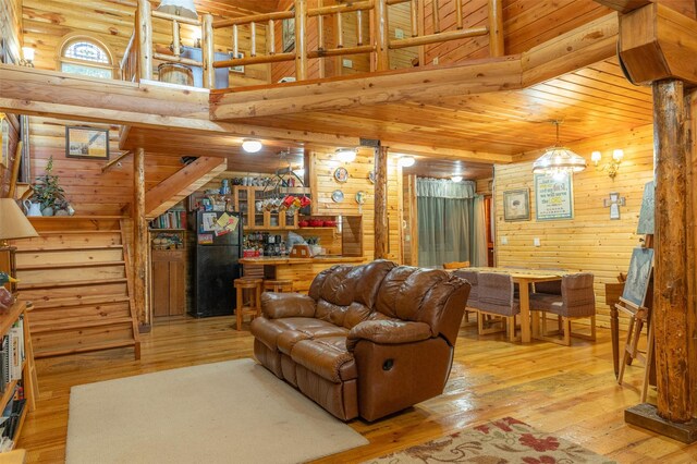 659 US Highway 2 E, Columbia Falls, MT 59912 - living area featuring a high ceiling, wood-type flooring, an inviting chandelier, and wooden walls