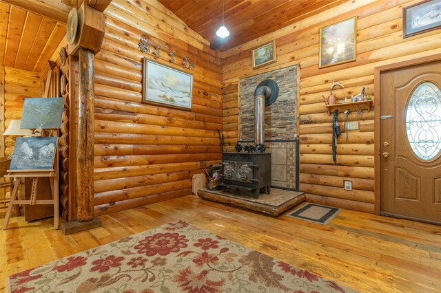 659 US Highway 2 E, Columbia Falls, MT 59912 - unfurnished living room with rustic walls, wooden ceiling, wood-type flooring, a wood stove, and vaulted ceiling