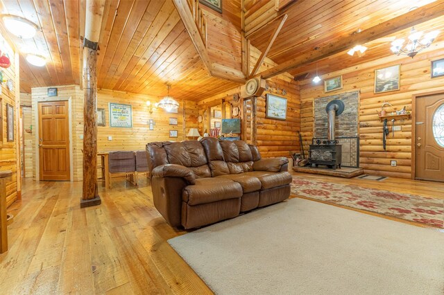 659 US Highway 2 E, Columbia Falls, MT 59912 - living area featuring wood ceiling, a wood stove, log walls, and light wood finished floors