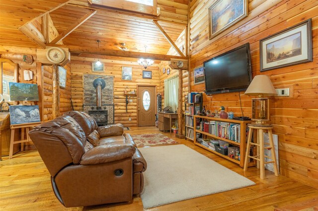 659 US Highway 2 E, Columbia Falls, MT 59912 - living room featuring wood ceiling, wood finished floors, a wood stove, log walls, and high vaulted ceiling