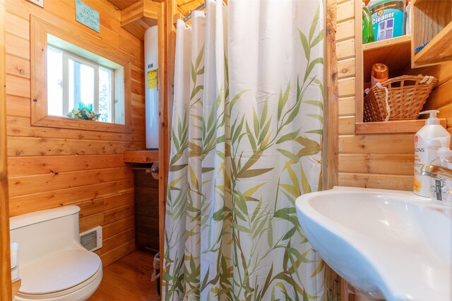 659 US Highway 2 E, Columbia Falls, MT 59912 - full bathroom featuring toilet, a sink, visible vents, and wooden walls