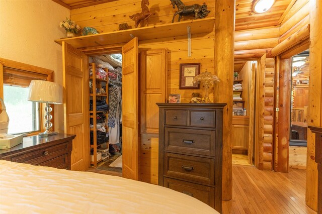 659 US Highway 2 E, Columbia Falls, MT 59912 - bedroom featuring light wood-style floors, a spacious closet, log walls, and a closet