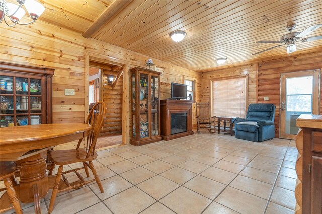 659 US Highway 2 E, Columbia Falls, MT 59912 - living area featuring log walls, light tile patterned floors, a glass covered fireplace, ceiling fan, and wooden ceiling