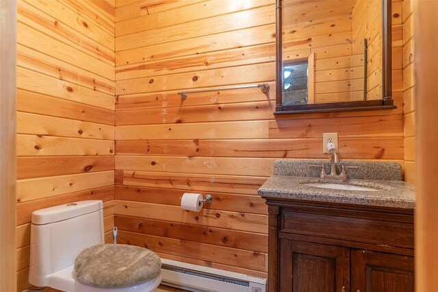 659 US Highway 2 E, Columbia Falls, MT 59912 - bathroom featuring wood walls, toilet, vanity, and baseboard heating