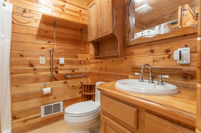 659 US Highway 2 E, Columbia Falls, MT 59912 - half bath with toilet, wooden walls, visible vents, and vanity