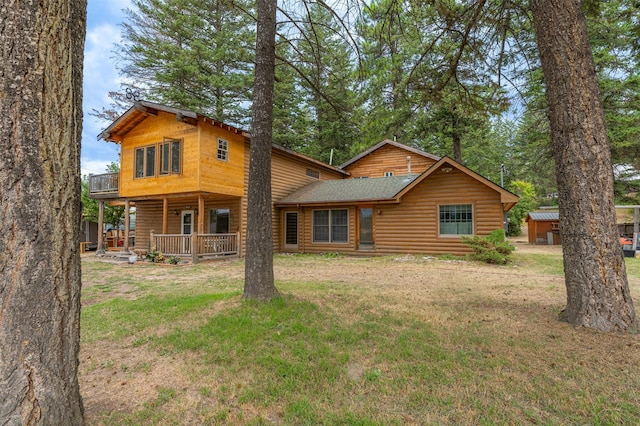 rear view of property featuring a porch and a lawn