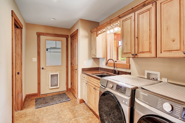 washroom with cabinets, sink, light tile patterned flooring, and washer and clothes dryer