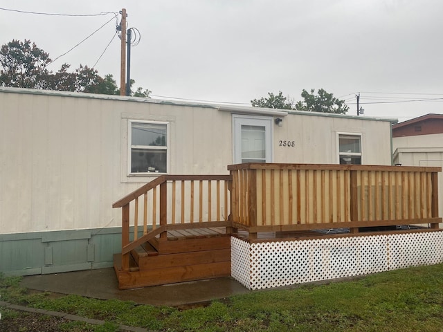 rear view of house featuring a wooden deck