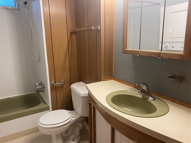 full bathroom with shower / tub combination, stacked washer / dryer, toilet, and sink