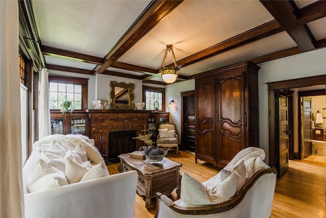 living room featuring a brick fireplace, light hardwood / wood-style flooring, beam ceiling, and coffered ceiling