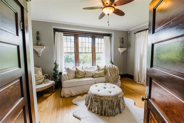 sitting room featuring ornamental molding, light wood-type flooring, and ceiling fan