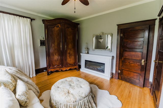 living room with ceiling fan, light hardwood / wood-style flooring, and crown molding