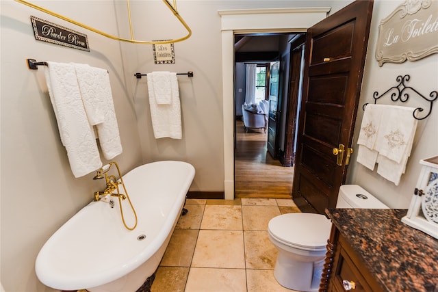 bathroom featuring toilet, vanity, a tub, and hardwood / wood-style flooring