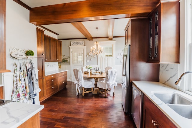 kitchen with hanging light fixtures, sink, stainless steel appliances, an inviting chandelier, and dark hardwood / wood-style flooring