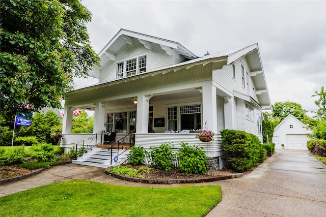 view of front of house featuring an outbuilding, a garage, and covered porch