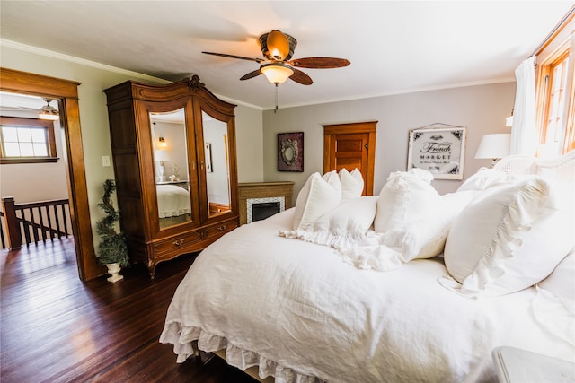 bedroom with ceiling fan, crown molding, and dark hardwood / wood-style flooring