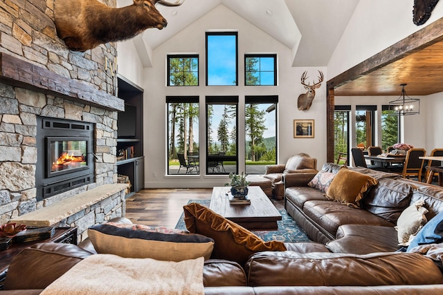 living room with plenty of natural light, high vaulted ceiling, a chandelier, and hardwood / wood-style flooring