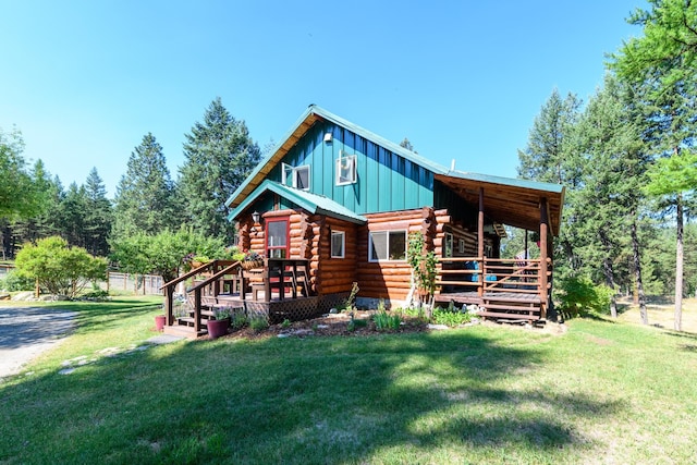 log home featuring a wooden deck and a front yard