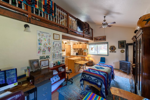 interior space with a wood stove, hardwood / wood-style floors, and high vaulted ceiling