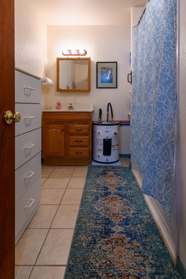 bathroom featuring electric water heater, tile patterned floors, and vanity