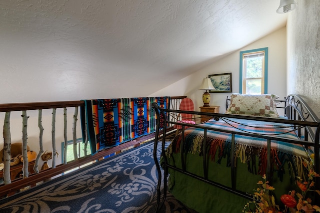 bedroom with a textured ceiling and lofted ceiling