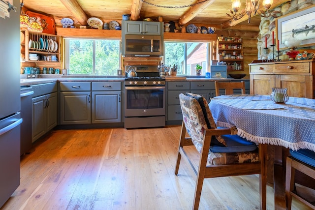 kitchen with light wood-type flooring, stainless steel appliances, and wood ceiling