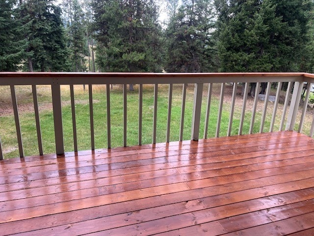 wooden deck featuring a lawn