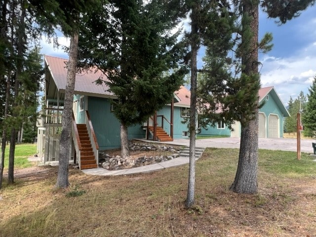 back of property with a garage and a yard