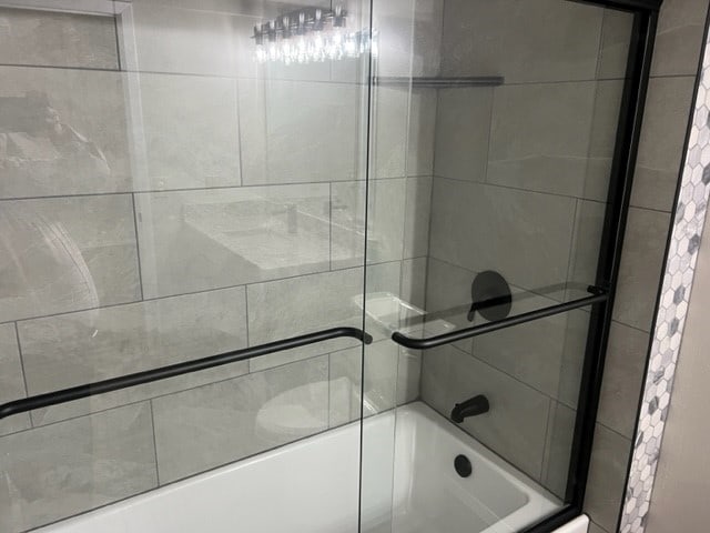 bathroom with shower / bath combination with glass door