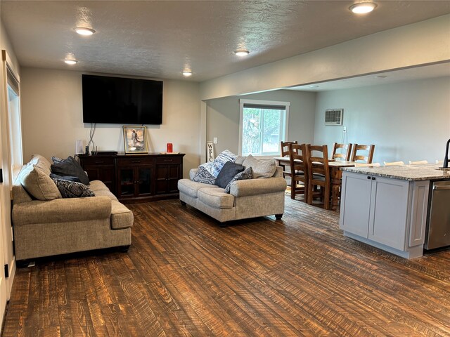 living room featuring a textured ceiling, sink, and dark hardwood / wood-style floors