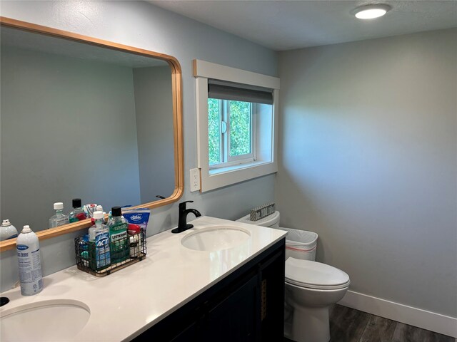 bathroom with toilet, hardwood / wood-style flooring, and vanity