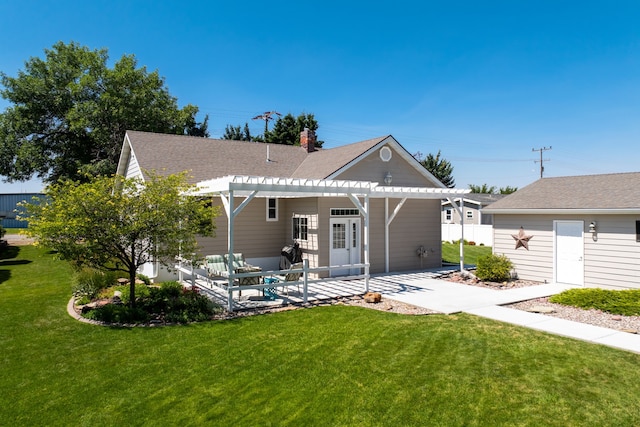 rear view of property featuring an outdoor structure, a lawn, and a pergola