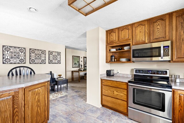 kitchen with appliances with stainless steel finishes and a textured ceiling