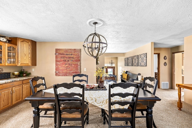 carpeted dining area with a chandelier