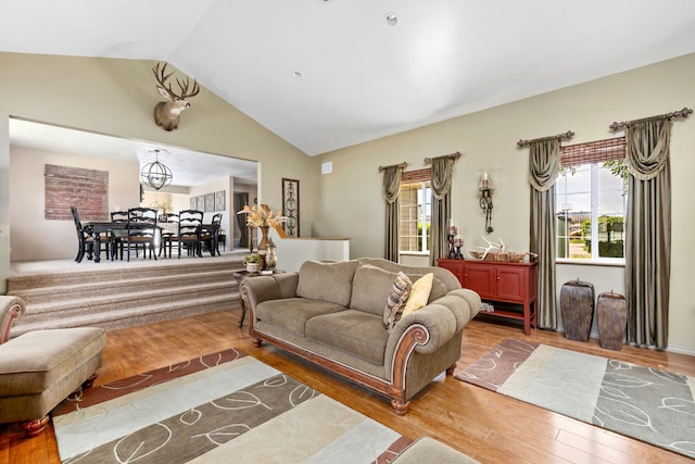 living room with wood-type flooring, plenty of natural light, and lofted ceiling