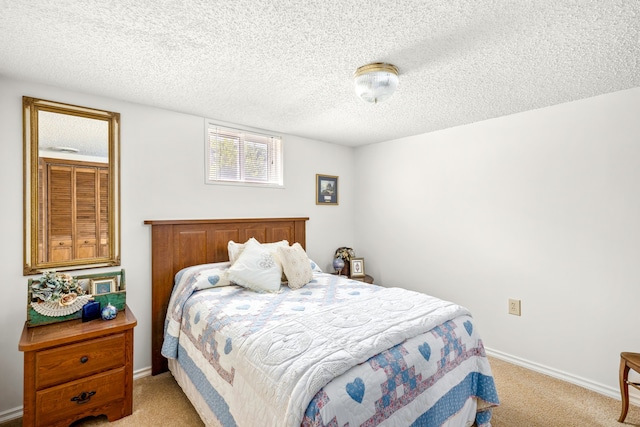 bedroom with light colored carpet and a textured ceiling