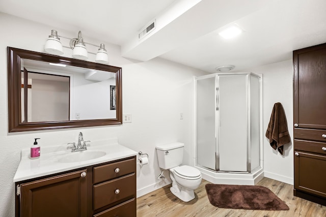 bathroom with vanity, hardwood / wood-style flooring, toilet, and walk in shower