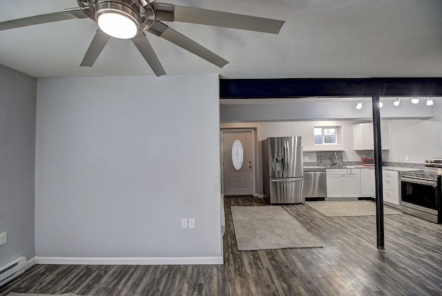 kitchen with appliances with stainless steel finishes, white cabinets, dark hardwood / wood-style flooring, baseboard heating, and beam ceiling