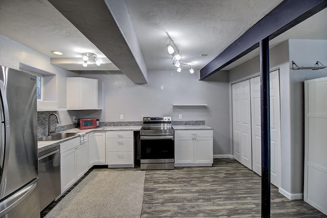 kitchen with sink, stainless steel appliances, dark hardwood / wood-style floors, a textured ceiling, and white cabinets